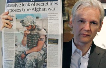 Wikileaks founder Julian Assange holds up a copy of a newspaper during a press conference at the Frontline Club in central London