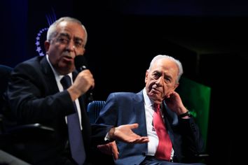 Israeli President Peres listens to Palestinian Prime Minister Fayyad during a special session addressing peace in the Middle East at the Clinton Global Initiative in New York