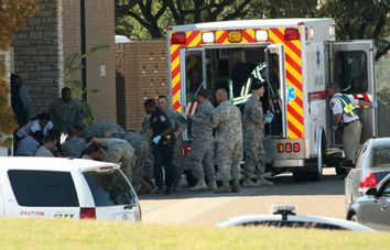 First responders prepare the wounded for transport in waiting ambulances outside Fort Hood's Soldier Readiness Processing Center