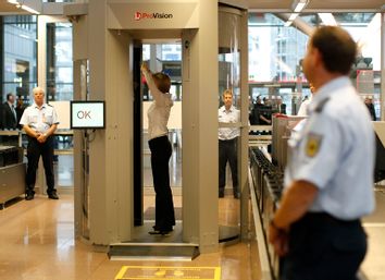 Security official demonstrates full body scanner during  photocall at Hamburg Airport