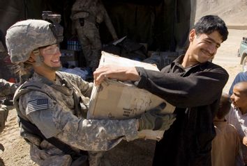 U.S. Private Johnson gives a box to an Afghan man during a hospital supply delivery in the village of Dah-e-Naw, Afghanistan