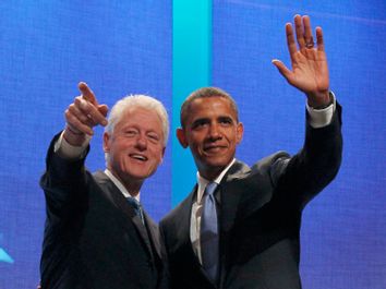U.S. President Barack Obama waves to the audience alongside former U.S. President Bill Clinton at the Clinton Global Initiative in New York