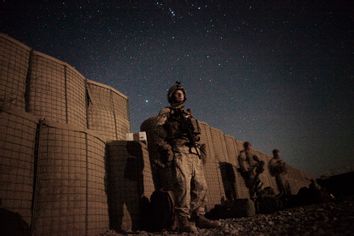 U.S. Marine waits in the moonlight for a helicopter to transport them home for leave from southern Afghanistan's Helmand province