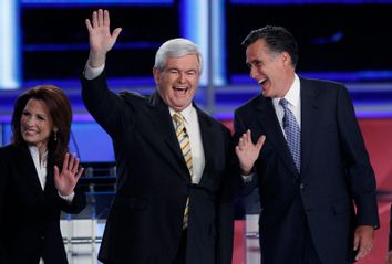 Republican presidential hopefuls Bachmann, Gingrich and Romney take the stage during a photo opportunity before the start of the first New Hampshire debate of the 2012 campaign at St. Anselms College in Manchester