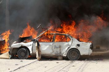 A car burns outside Hotel Madina during a protest in support of Prime Minister Mohamed Abdullahi Mohamed, in Mogadishu