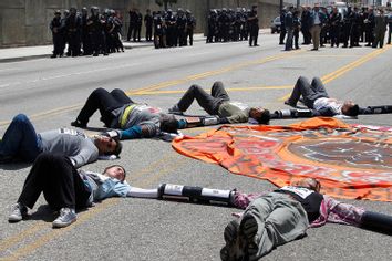 Protesters against Arizona's new law SB 1070 lie on a street with their hands linked together