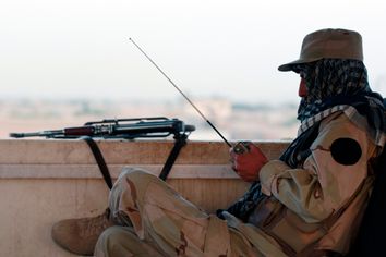 A private security organization contractor listens to a radio