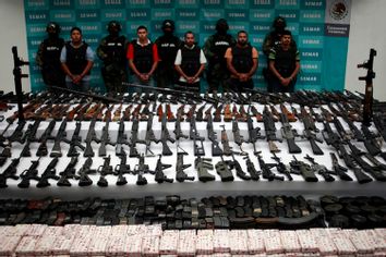 Suspects are lined up as weapons are displayed to the media by the Mexican Navy in Mexico City June 9, 2011.