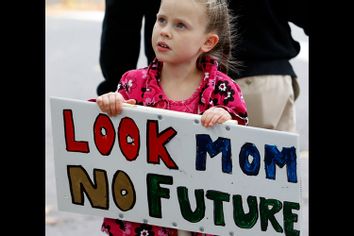 Abigail Garrett, 6, of Hamden, Connecticut holds a sign during an Occupy New Haven march in New Haven, Connecticut
