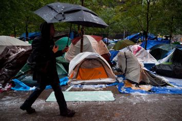 A pedestrian walks by snow covered Occupy Wall Street tents during a snowstorm in Zuccotti Park, Saturday, Oct. 29, 2011, in New York.