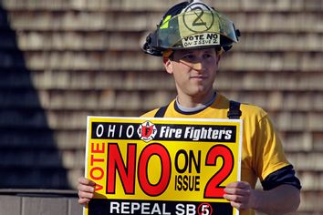 Firefighter Tom Sullivan campaigns against Issue 2 outside a polling location in Strongsville, Ohio Tuesday, Nov. 8, 2011.