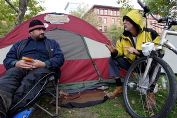Protesters who gave their names as Trev H., left, and Philippe D'Orlando, right, both homeless, talk outside a tent in a Burnside Park where Occupy Providence protesters are camping in downtown Providence, R.I.