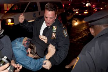 An Occupy Wall Street protester draws contact from a police officer near Zuccotti Park after being ordered to leave the longtime encampment in New York, Nov. 15, 2011