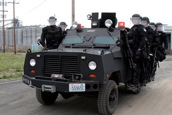 Police in riot gear move to another location at the port facilities in Longview, Wash., Wednesday, Sept. 21, 2011.