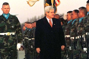 U.S. House Speaker Newt Gingrich (C) reviews U.S. military honor guards upon his arrival at a U.S. air base in Osan, South Korea, March 24, 1997.