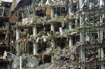 Debris hangs from the front of the federal building after a 1200 pound car bomb blew off the north s..