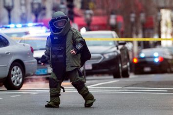 Law enforcement bomb technician walks away after preparing controlled detonation of a suspicious object during a search for a suspect in the Boston Marathon bombing, in Boston