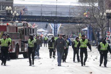 Public safety officials evacuate the scene after several explosions near the finish line of the 117th Boston Marathon in Boston