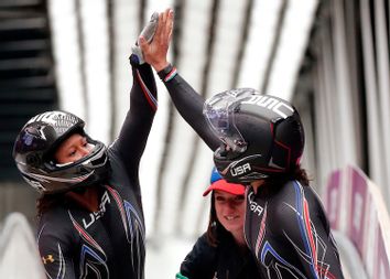 Pilot Elana Meyers and Lauryn Williams of the U.S. high-five after completing a run in the women's bobsleigh competition at the 2014 Sochi Winter Olympics