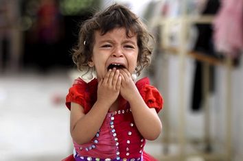 A girl cries as she walks onto the veranda at the yard of a school sheltering people displaced by Saudi-led air strikes on Yemen's northwestern province of Saada, in the capital Sanaa