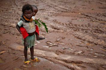 Children stand during rain in front of Saint Michel Catholic church in the town of Boda