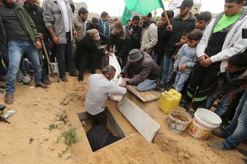 Mourners bury the body of 10-year-old Palestinian boy Yassin Abu Khoussa, whom medical officials said was killed by fragments from a missile fired by an Israeli aircraft, at a cemetery in the northern Gaza Strip