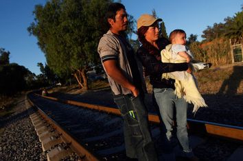 An illegal Salvadoran migrant couple is seen on railway track with their son Andrew, six months, during the arrival of the 