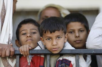 Boys wait to receive food vouchers at a food distribution center for poor families in Yemen's capital Sanaa