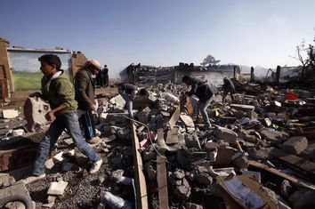 People search for belongings amid the wreckage of the damaged school cafeteria near an amusement park after it was hit by Saudi-led air strikes in Yemen's capital Sanaa