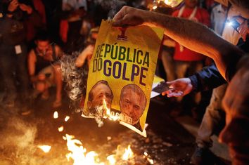 Members of Brazil's MTST burn a poster with the images of President of the Brazilian Senate Renan Calheiros and Brazil's interim President Michel Temer in Sao Paulo