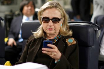 U.S. Secretary of State Hillary Clinton checks her PDA upon her departure in a military C-17 plane from Malta bound for Tripoli,  Libya