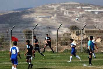 Players from Israeli soccer clubs affiliated with Israel Football Association, Ariel Municipal Soccer Club and Maccabi HaSharon Netanya, play against each other at Ariel Municipal Soccer Club's training grounds in the West Bank Jewish settlement of Ariel