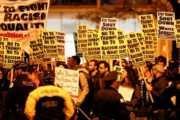 Protesters hold signs during a protest against Republican president-elect Donald Trump outside Trump International Hotel and Tower in Chicago