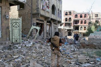 A pro-government fighter walks at the site of recent battles between Houthi fighters and pro-government fighters, on the second day of a 48-hour ceasefire in the southwestern city of Taiz, Yemen