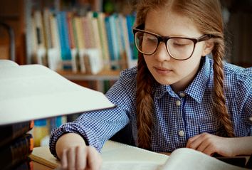 Girl Surrounded with Stacks of Books