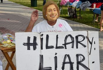 A man wears a Hillary Clinton mask