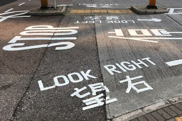 Traffic signs on the ground, English and Chinese languages