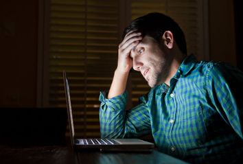 Man stressing on laptop late at night