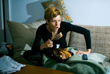 Woman eating turkey on couch