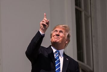 Donald Trump looking at the eclipse