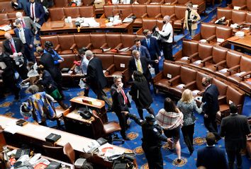 Members of Congress evacuate the House Chamber