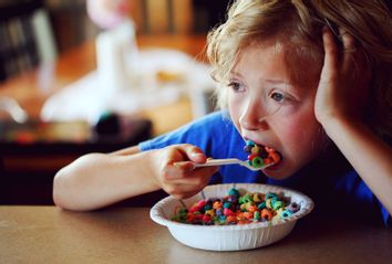 Boy Eating Multi Colored Breakfast Cereal