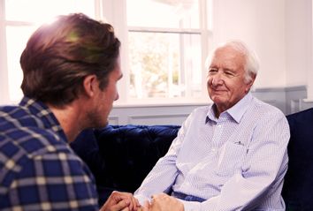 Adult Son Talking To Father At Home