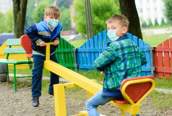 Children at the park wearing face masks