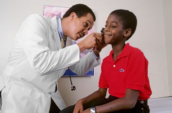 Doctor treating boy patient at a checkup