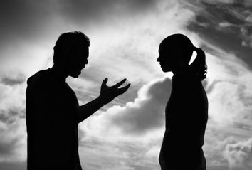 Silhouette of a man arguing with a woman