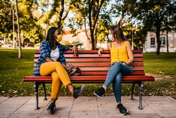 Friends keeping social distance on bench