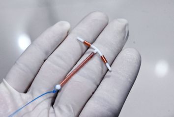 A doctor holding an IUD birth control device 