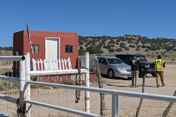 A security guard speaks to a person from the Office of the Medical Investigator at the entrance to the Bonanza Creek Ranch on October 22, 2021 in Santa Fe, New Mexico.