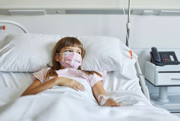 Sick girl lying on bed in ICU during COVID-19